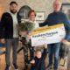 Meneer en mevrouw Revier ontvangen de Keuken Kampioen cheque uit handen van Otis Lalihatu, copywriter bij de Grote Clubactie