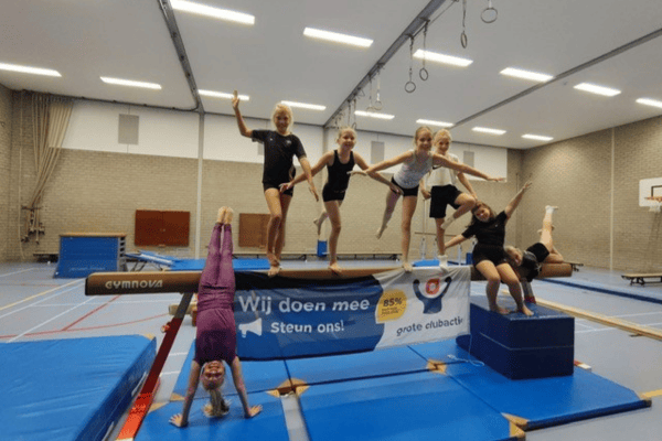 Persbericht Groepsfoto van jeugdleden bij het Grote Clubactie spandoek op hun vereniging